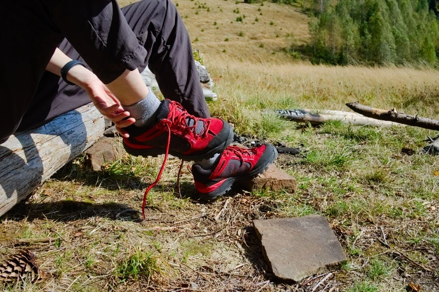 Young traveler girl taking hiking shoes off