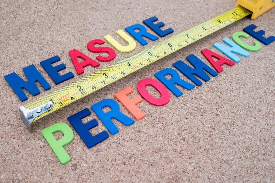  "Measure Performance" and measuring tape on cork board background