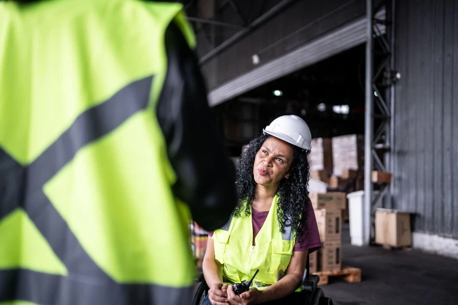 Disabled woman talking to a coworker in a warehouse