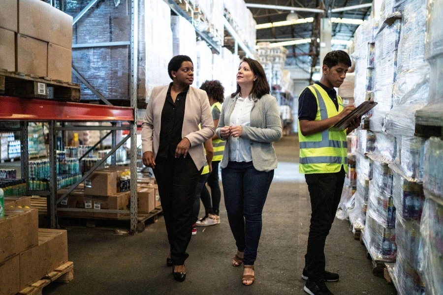 Coworkers talking while walking in a warehouse