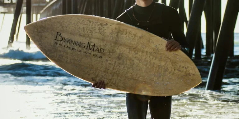 man holding brown skimboard