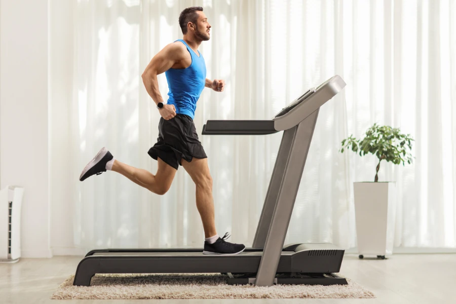 Seorang pria berlari di atas treadmill di rumah