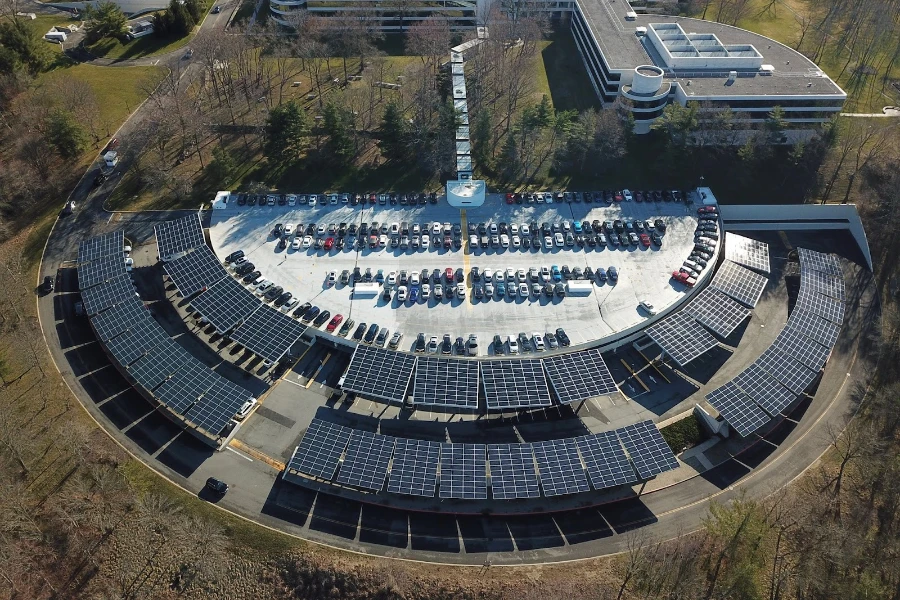 Outdoor array of solar carports in which a number of electric cars are parked