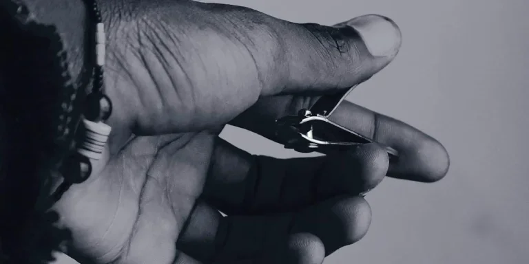 Person holding a traditional nail clipper
