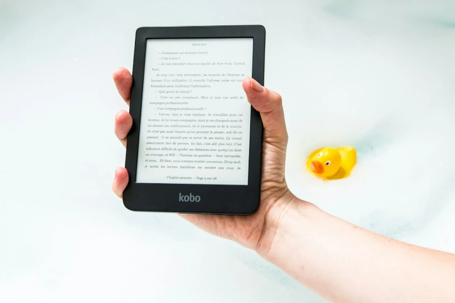 Person holding an e-reader above a bathtub
