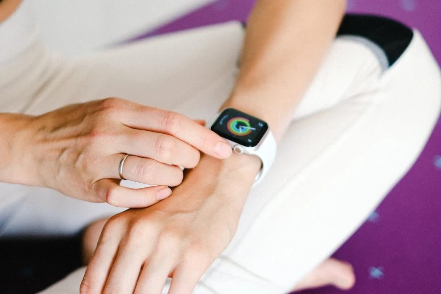 Persona mirando su Apple Watch mientras está sobre una estera de yoga