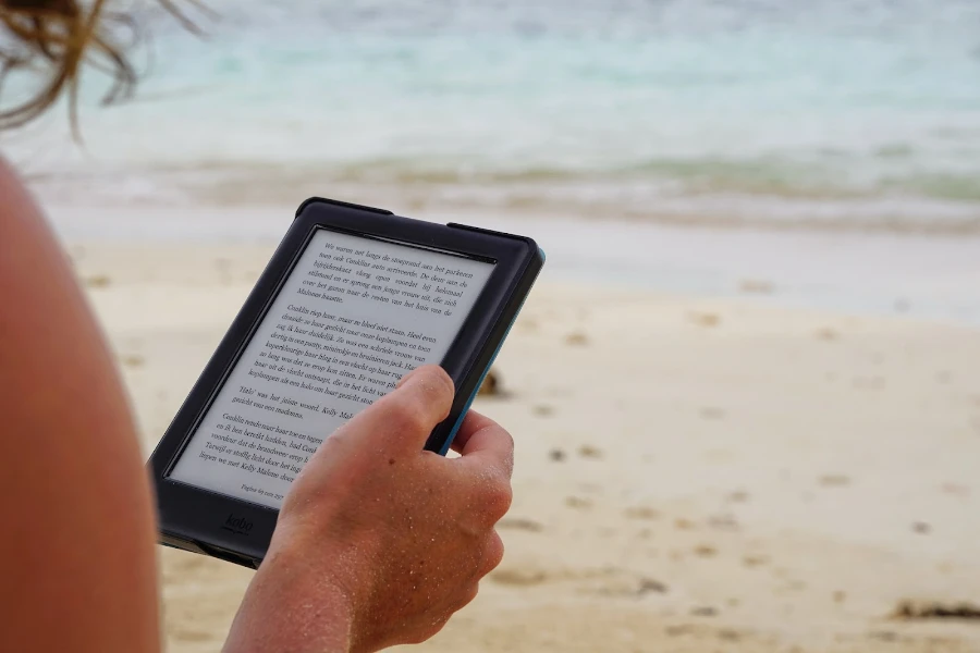 Person reading on an e-reader at the beach