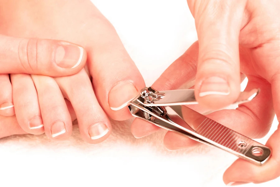 Person using a classic nail cutter on toenails
