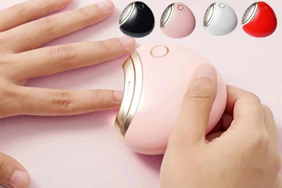 Человек, использующий розовую электрическую кусачку для ногтей