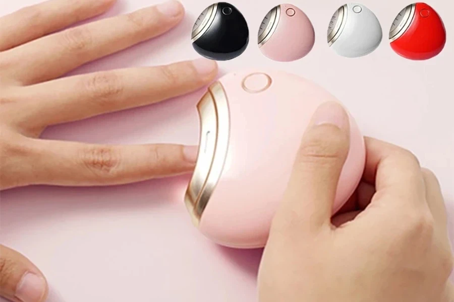 Person using a pink electric nail clipper