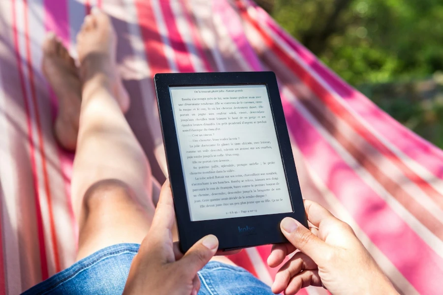 Person using an e-reader in a hammock