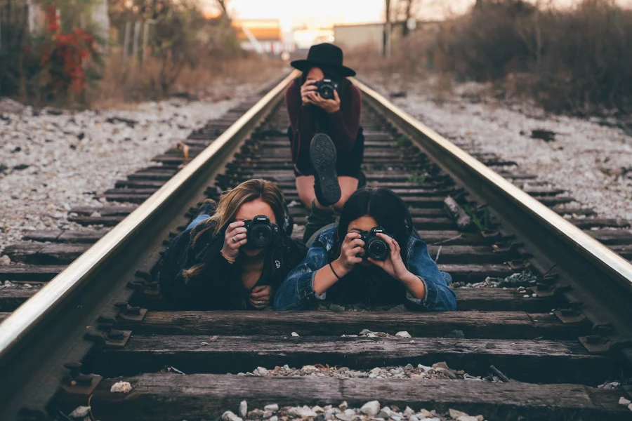 Photographers taking photos while lying on a railway track