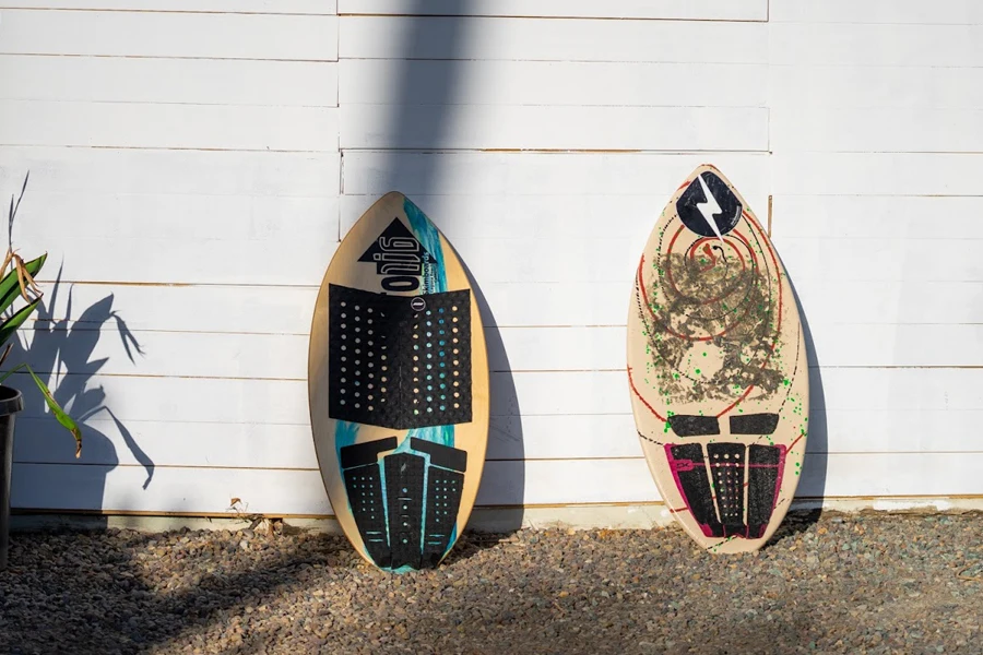two skimboards resting on a wall
