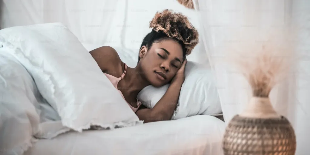 Mulher dormindo na cama com a cabeça apoiada em um travesseiro macio