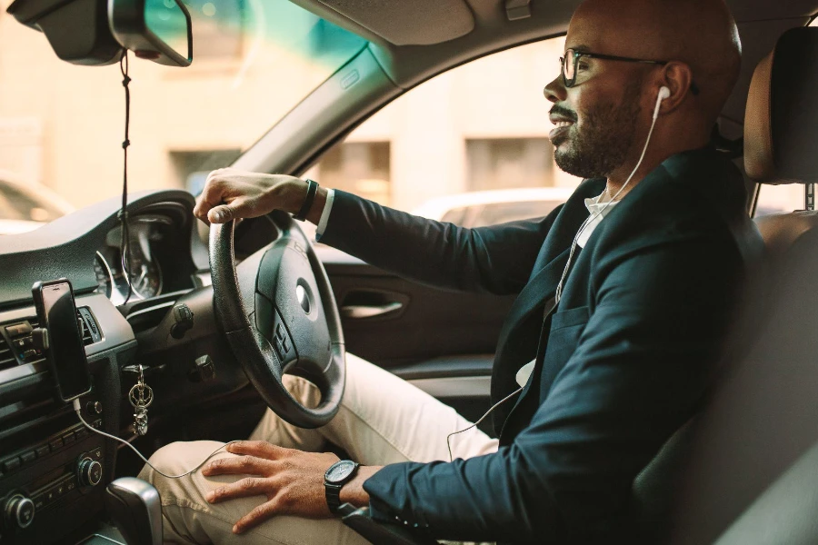 young man in suit making a call while driving car