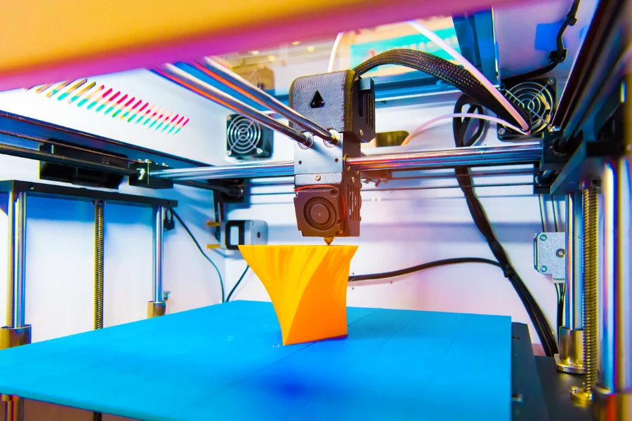 3D printer in action creating a yellow object