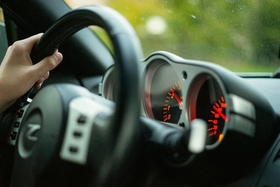 Una persona conduciendo un automóvil con una mano en el volante