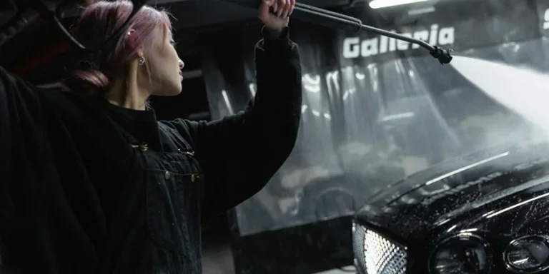 A Woman Washing a Car with a Power Spray