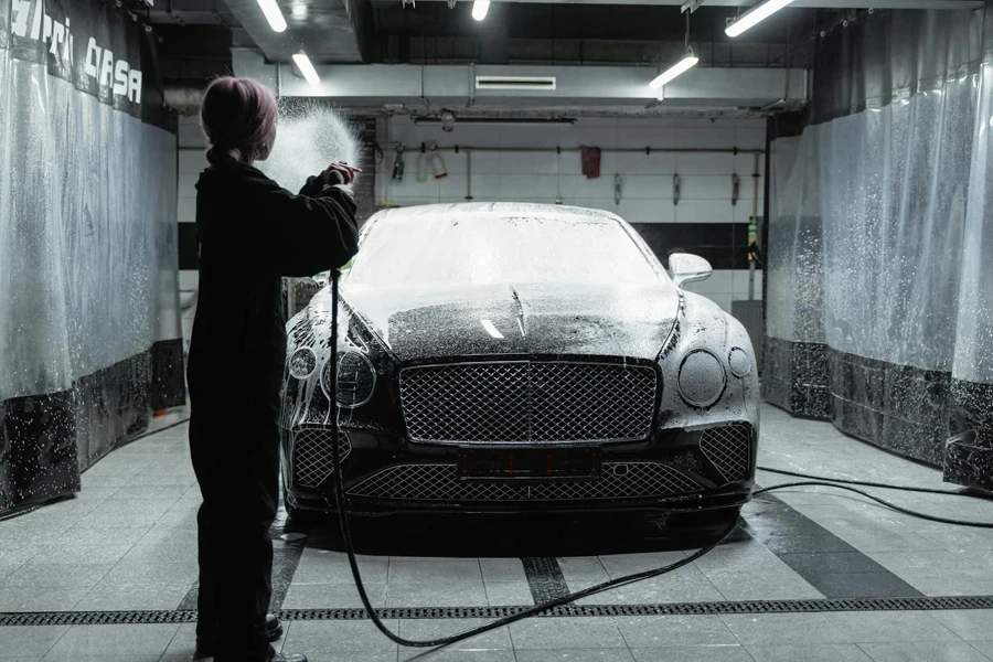 A Woman with Dyed Hair Washing a Car