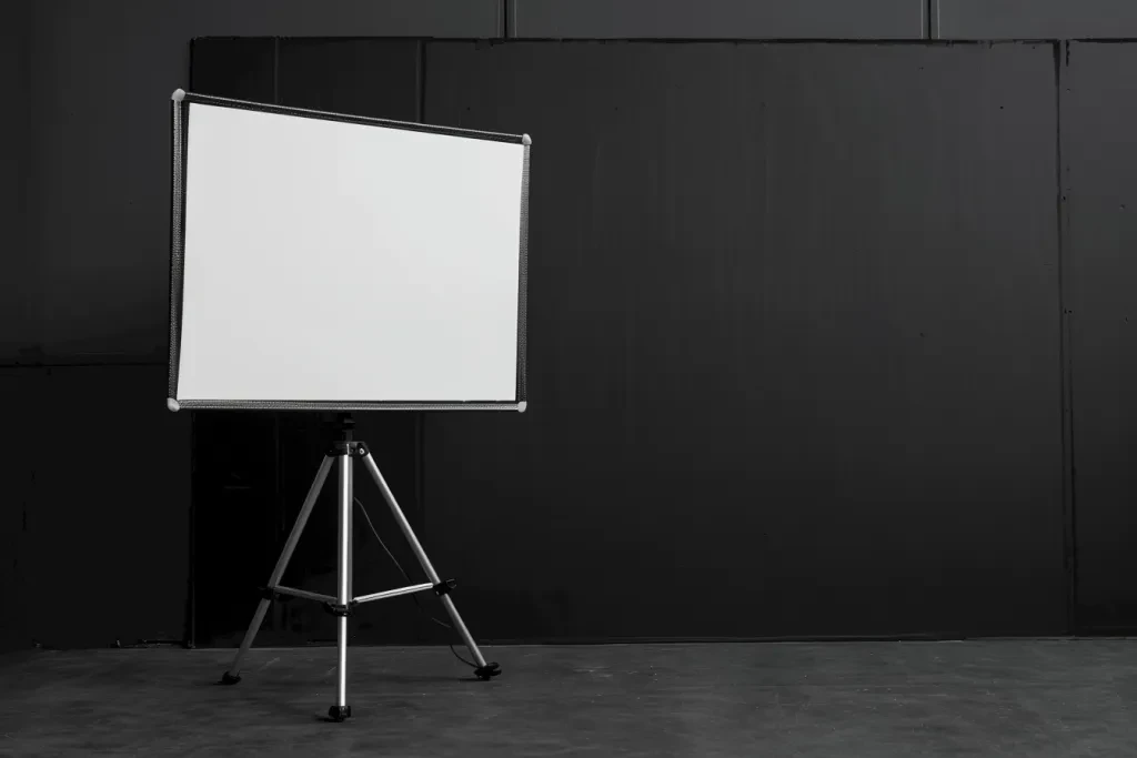 A blank white projector screen on a tripod