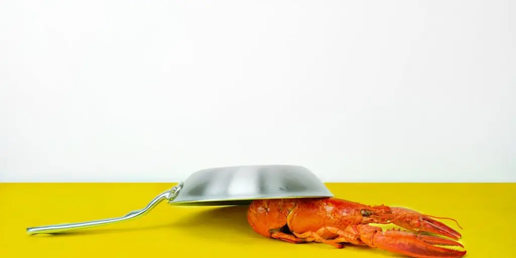 A cooking pan over a lobster