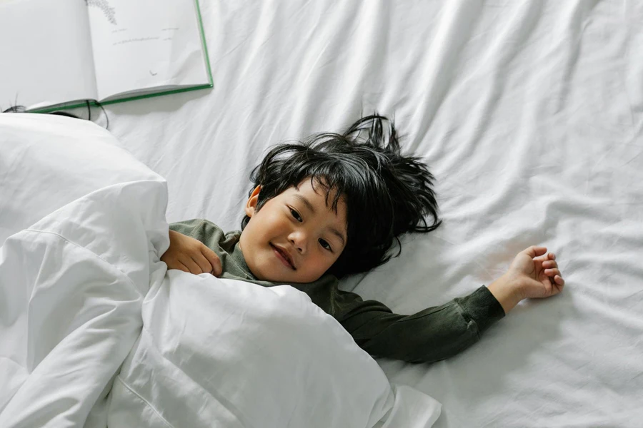 A kid lying in bed after sleep