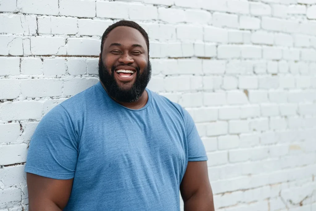 A mockup of an attractive African American plus size male model wearing blue heather grey crewneck tshirt