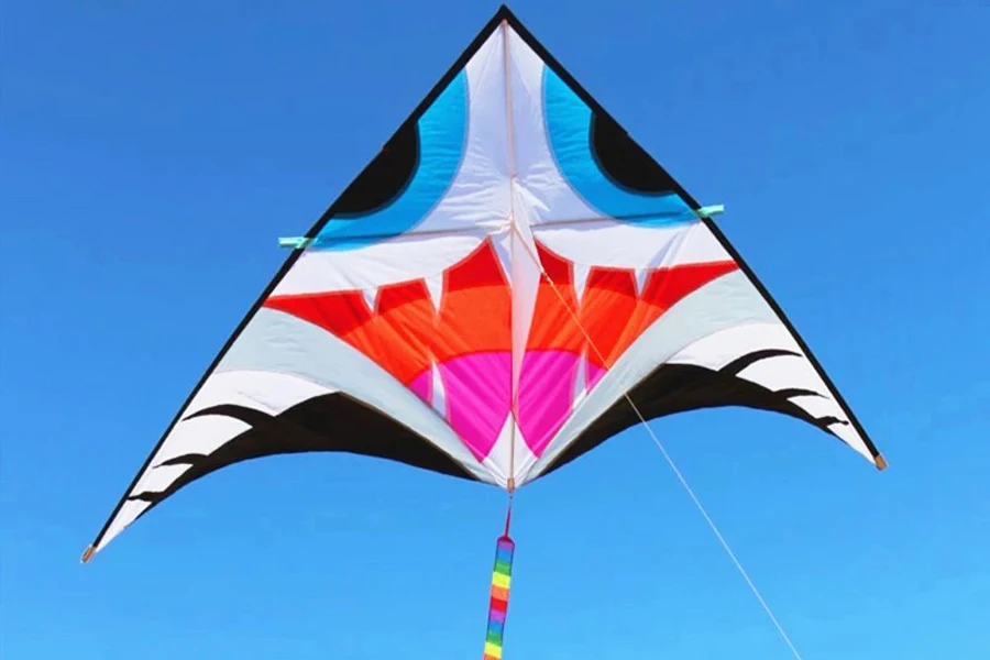 A multi-colored C kite suspended in the air