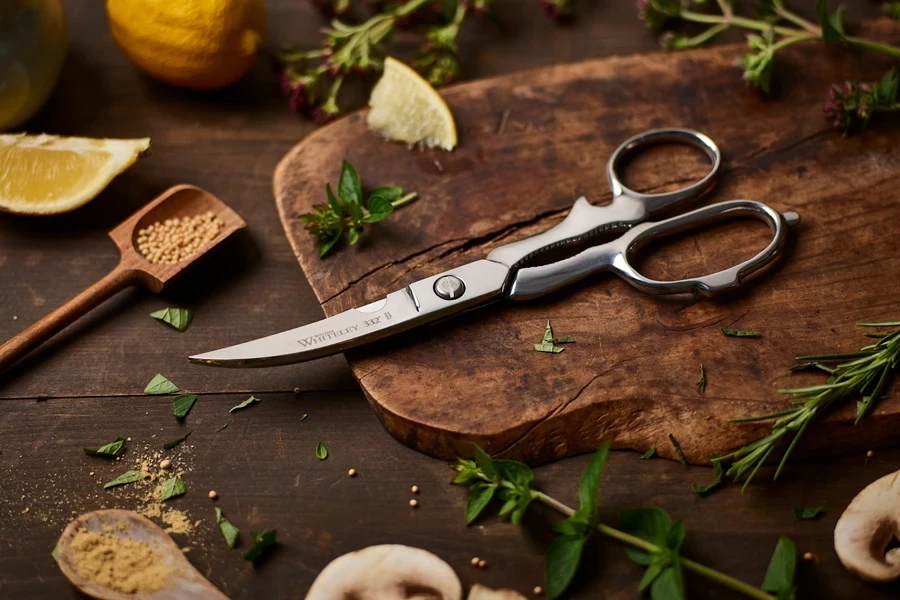 A pair of kitchen scissors on a chopping board