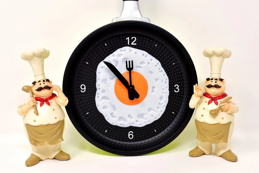 A unique kitchen timer between two toy chefs