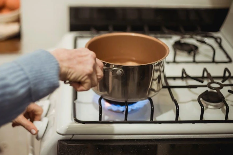 A woman heating a saucepan