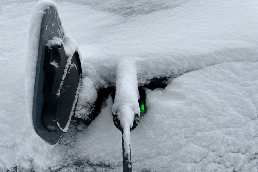 An electric car is charging in the snow