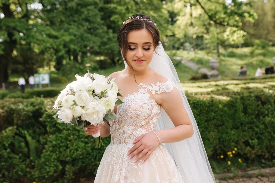 Beautiful bride in wedding dress walking in the park