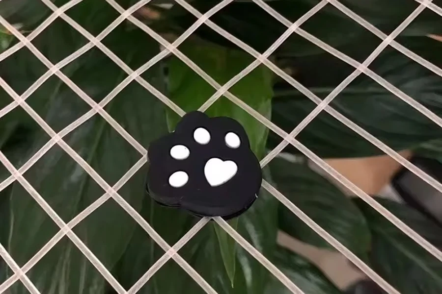 Black and white tennis dampener shaped like a paw