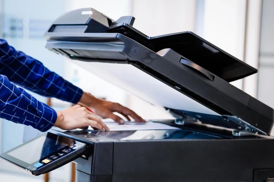 Businessmen press button on the panel for using photocopier or printer for printout and scanning document paper at office