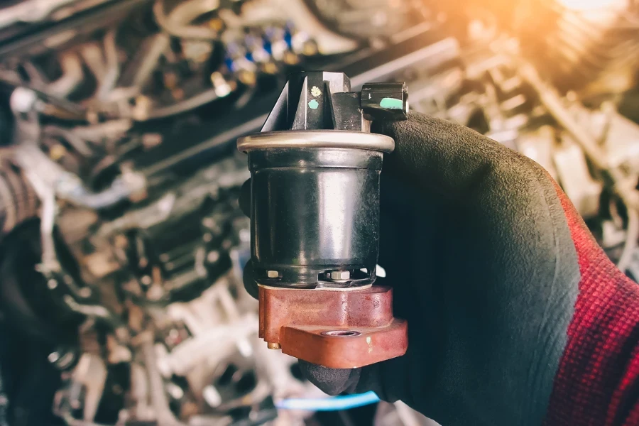 Close up of the EGR exhaust gas recirculation in the auto mechanic hand