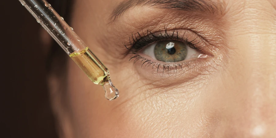 Closeup of female eye and dropper with rejuvenating serum