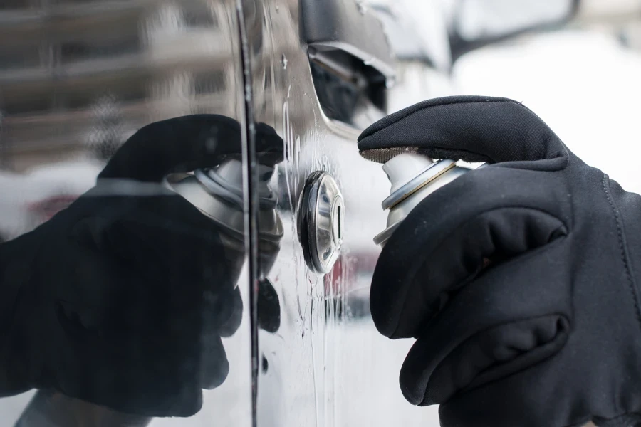 Closeup of man hand with lock door de-icer