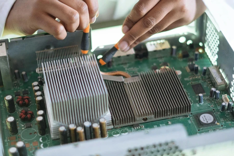 Crop technician checking contacts on motherboard in workshop