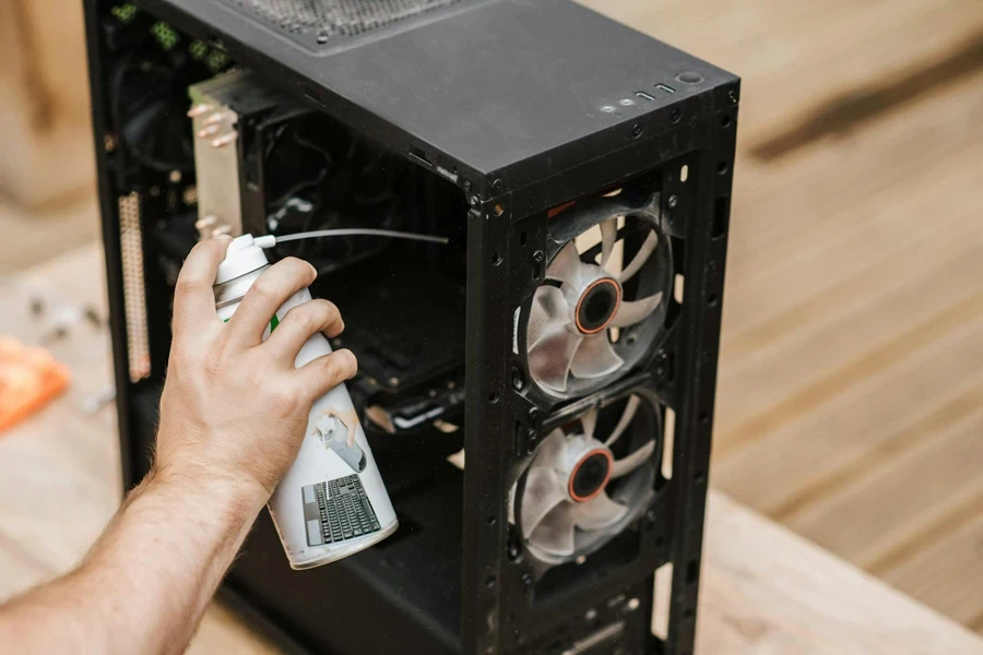 Crop unrecognizable man cleaning computer system unit 