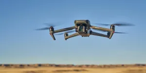 DJI foldable Mavic 3 drone flying over prairie