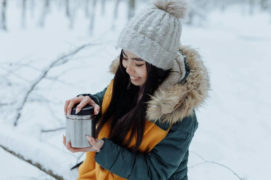 Lady holding a vacuum food jar in the snow