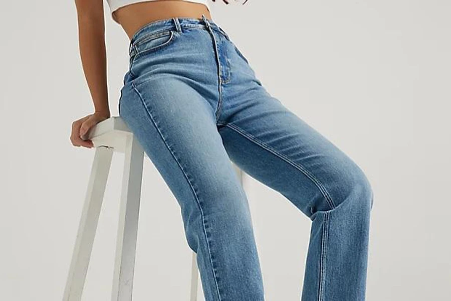 Lady sitting on a stool in high-waisted straight jeans