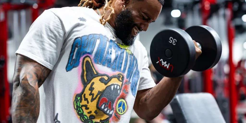 Muscular man lifting weights in an oversized gym shirt