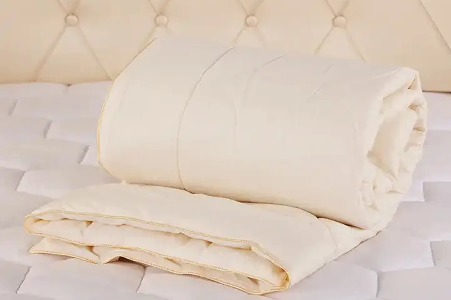 Natural wool doona folded on top of bed