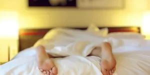 Person Lying on Bed Covering White Blanket