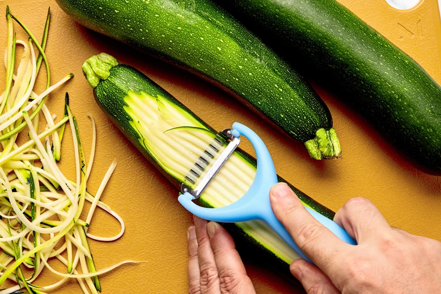 Person peeling a cucumber with a peeler