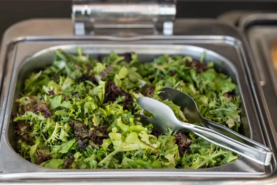 Salad tongs in a tray of salad