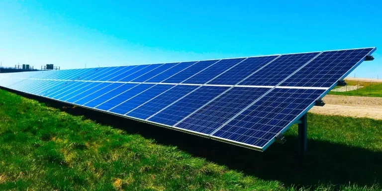 Solar panels in a green field with blue skies