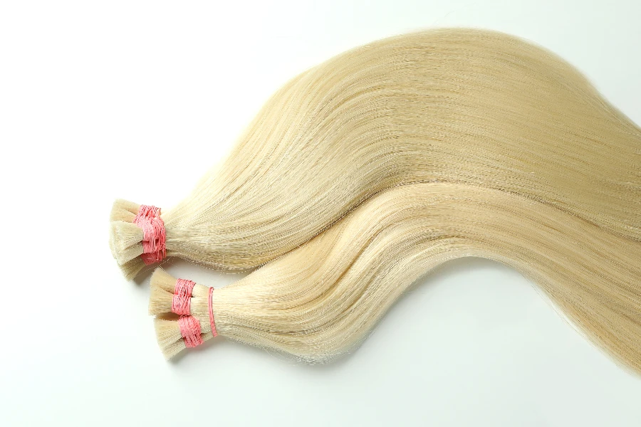 Strands of blond hair on white background